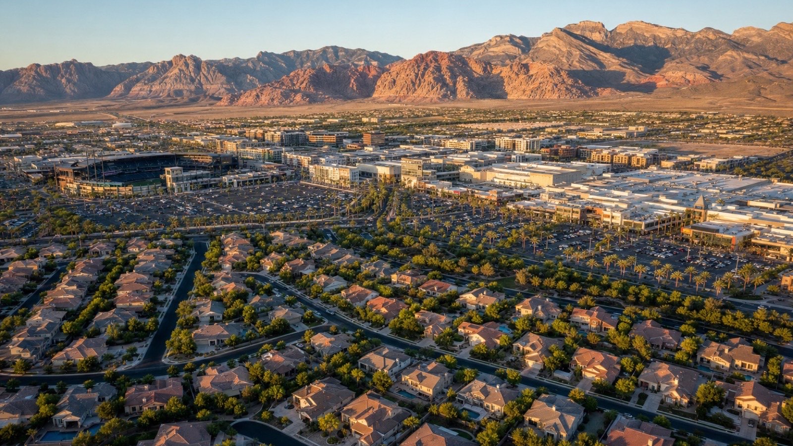 Aerial view of a Summerlin neighborhood with mountains in the background at golden hour
